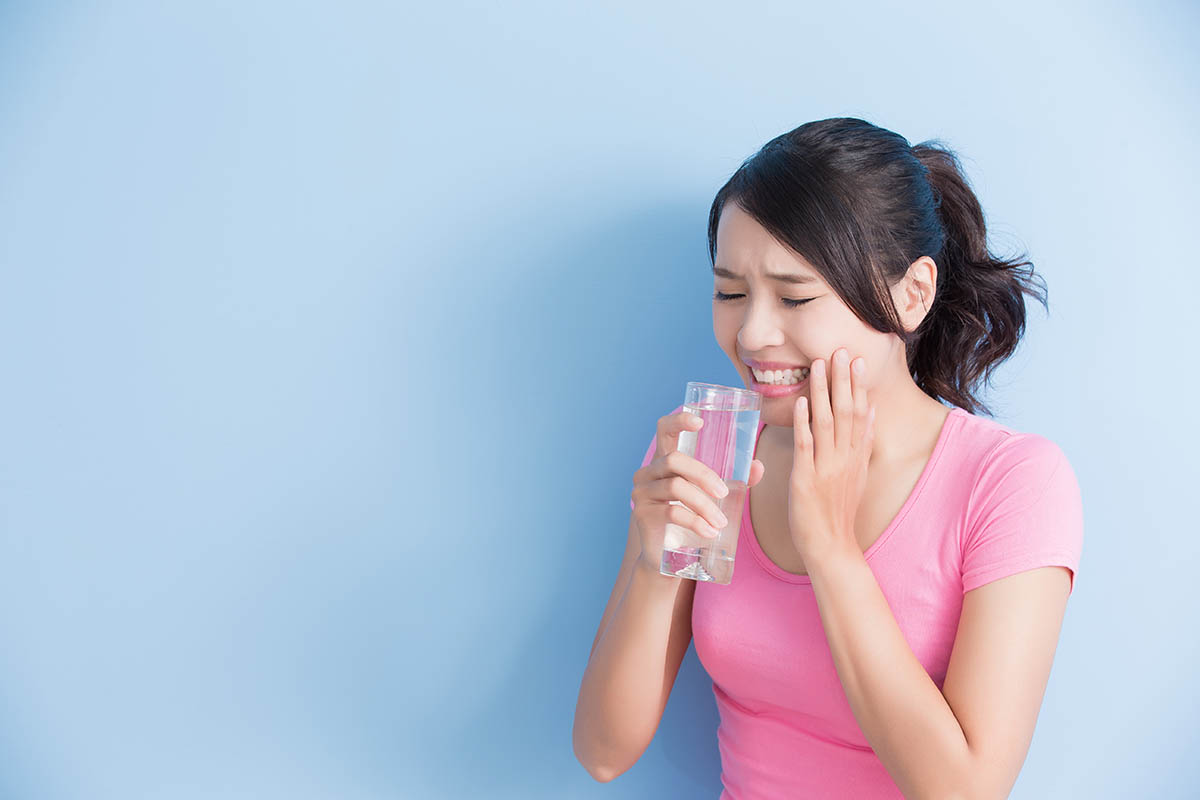 woman drink water with sensitive teeth 